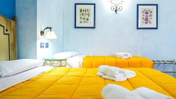Une chambre d’hôtel avec deux lits, une table de chevet, une lampe et deux tableaux encadrés au mur.