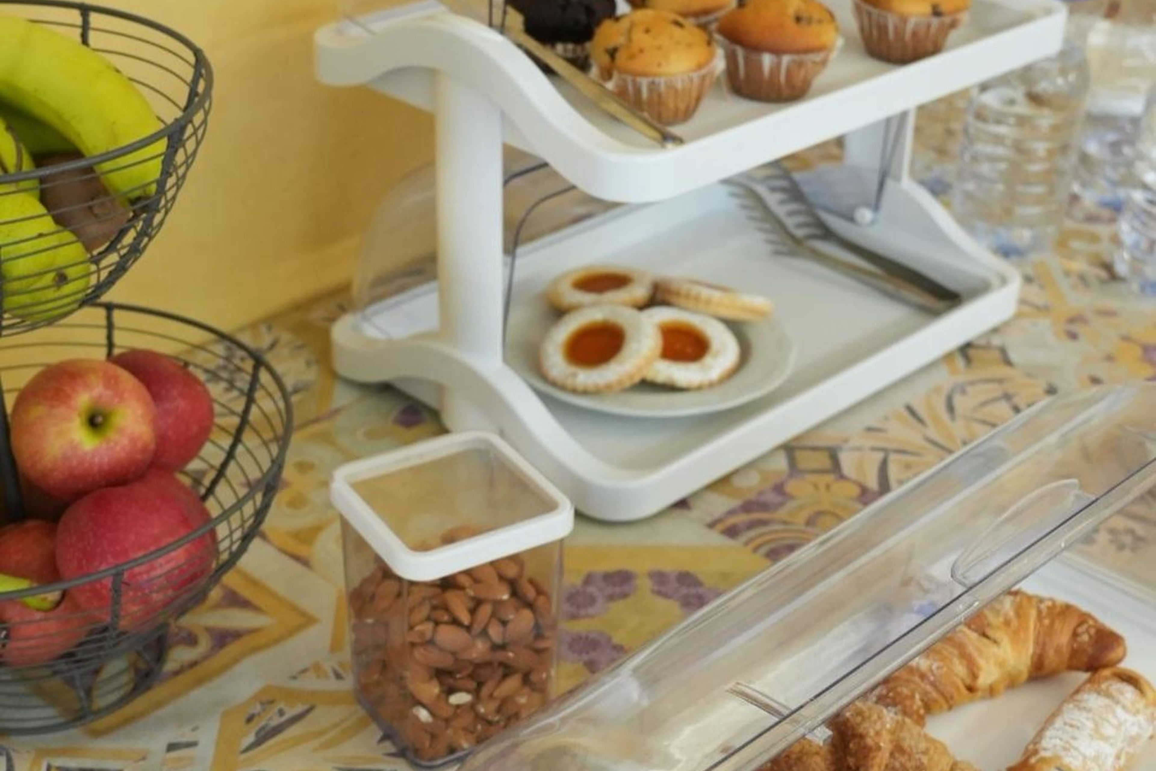 Un bufé de desayuno con frutas, muffins, galletas y bollería.