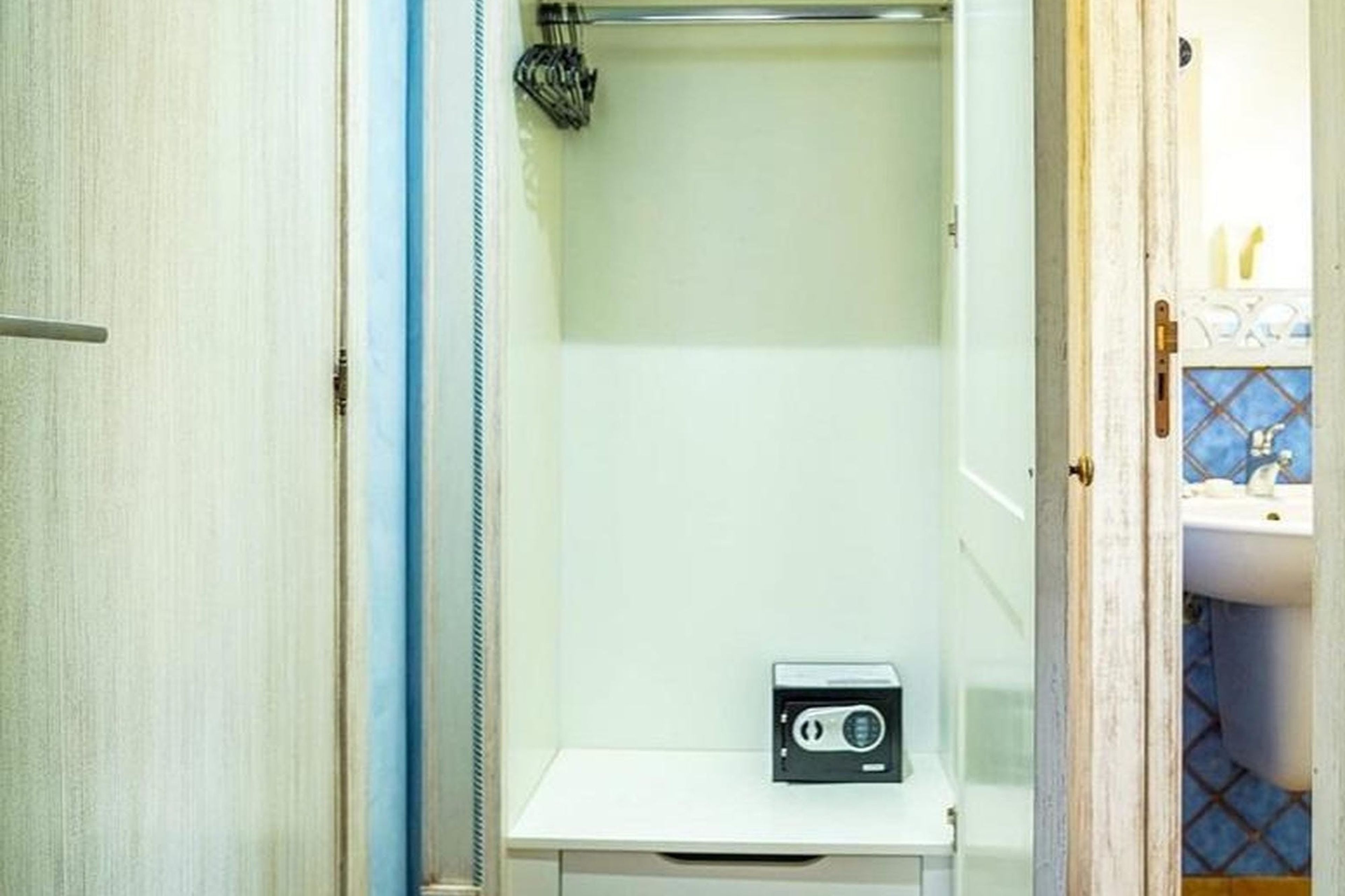 A bathroom with a shower, a small white cabinet, and a radio.
