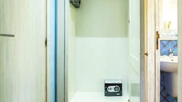 A bathroom with a shower, a small white cabinet, and a radio.