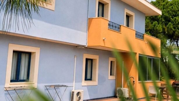 A two-story building with a balcony, windows, and outdoor furniture. - Motel - Hotel Nautico Pozzallo (Pozzallo)