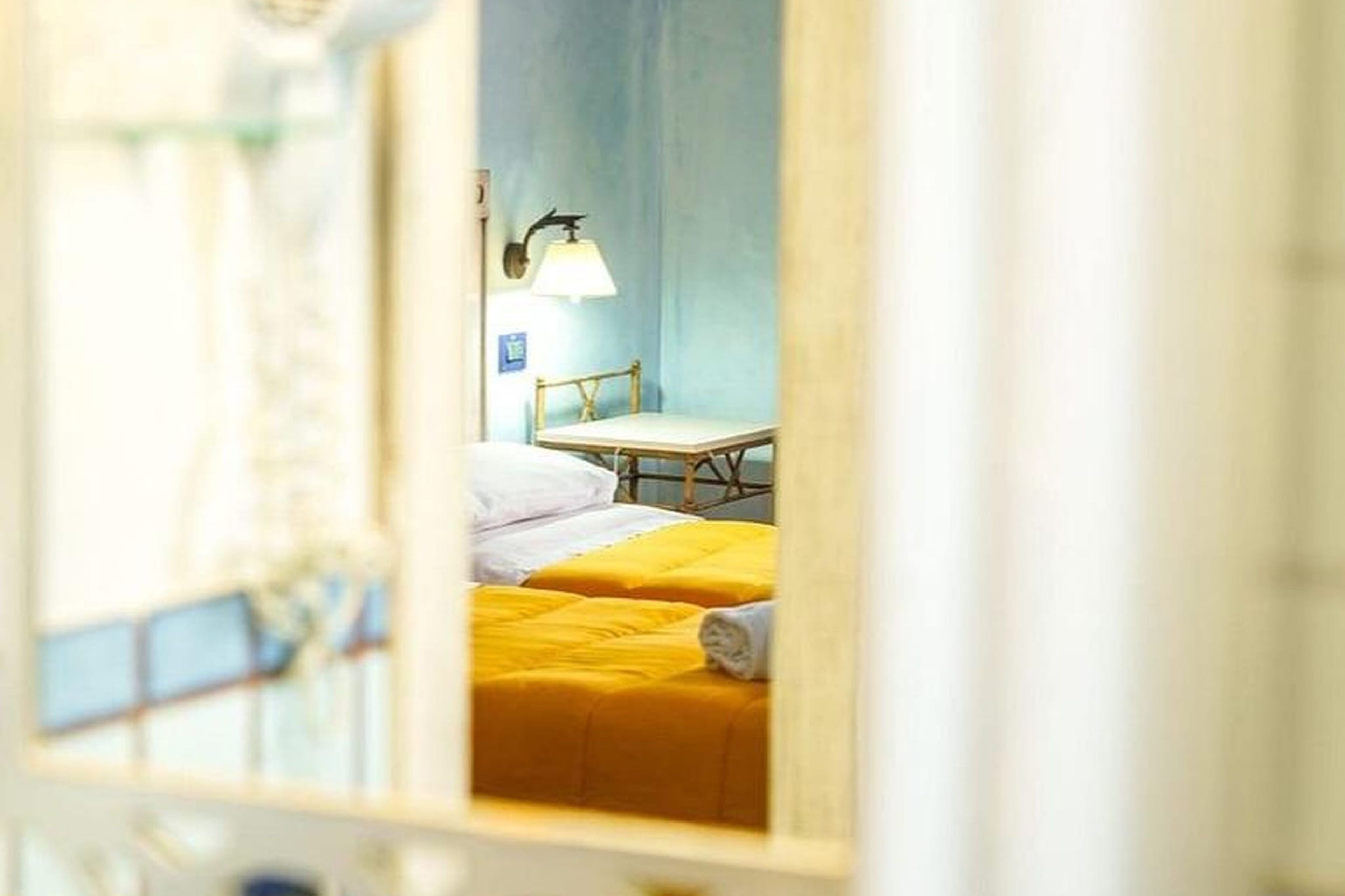 Una habitación de hotel con una cama, una mesa y una lámpara.