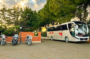 Un autobus parcheggiato in un'area asfaltata, con alberi sullo sfondo.