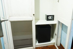 A small room with a white door, a black storage unit, and a white shelf with a radio. - Motel - Hotel Nautico Pozzallo (Pozzallo)