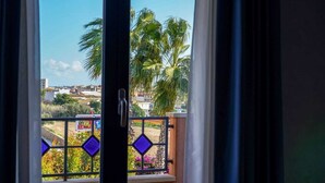 A view through a window with a balcony, featuring palm trees and a distant urban landscape. - Motel - Hotel Nautico Pozzallo (Pozzallo)