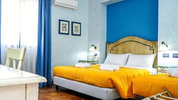 Una habitación de hotel con una cama doble, una silla, un escritorio y una ventana con cortinas.