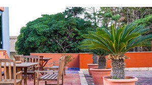 An outdoor patio with wooden furniture and large terracotta pots. - Motel - Hotel Nautico Pozzallo (Pozzallo)