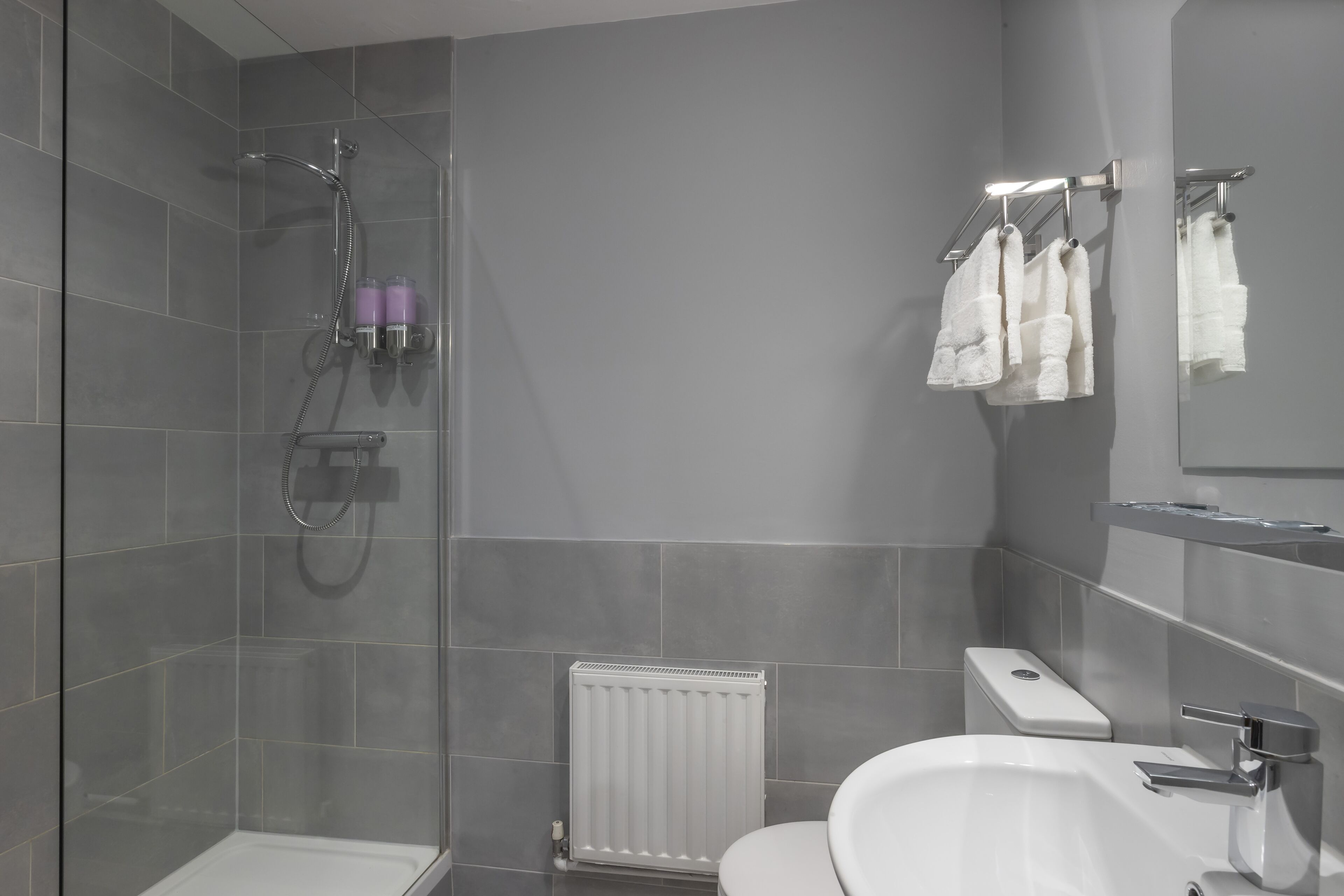 Un baño moderno con ducha, inodoro y lavabo.
