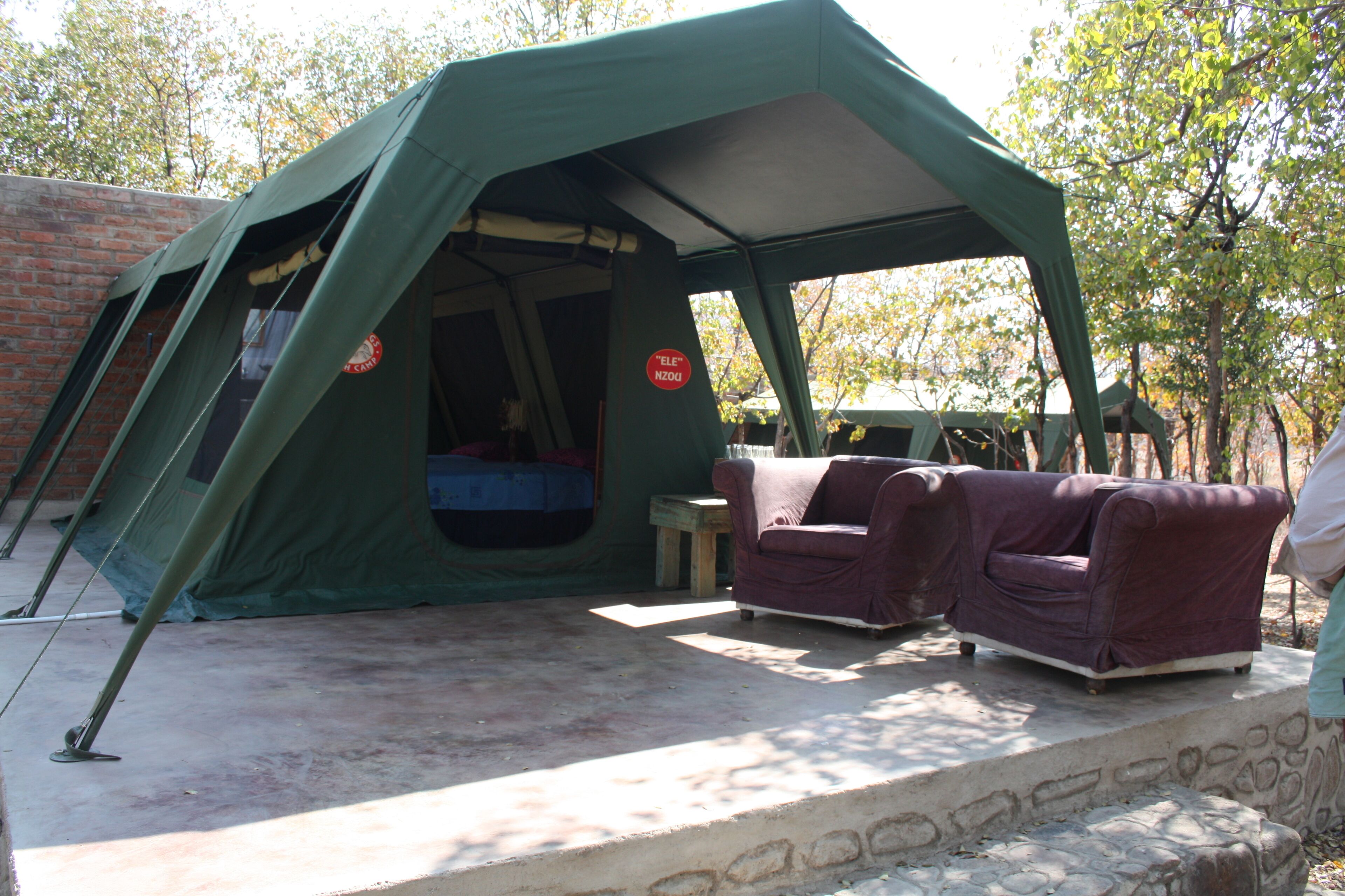 A tent with a sleeping area and two couches.