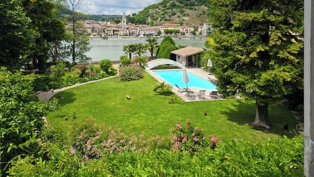 A pool area with a view of a town and hills in the background. - Villa Rhôna (Andancette)