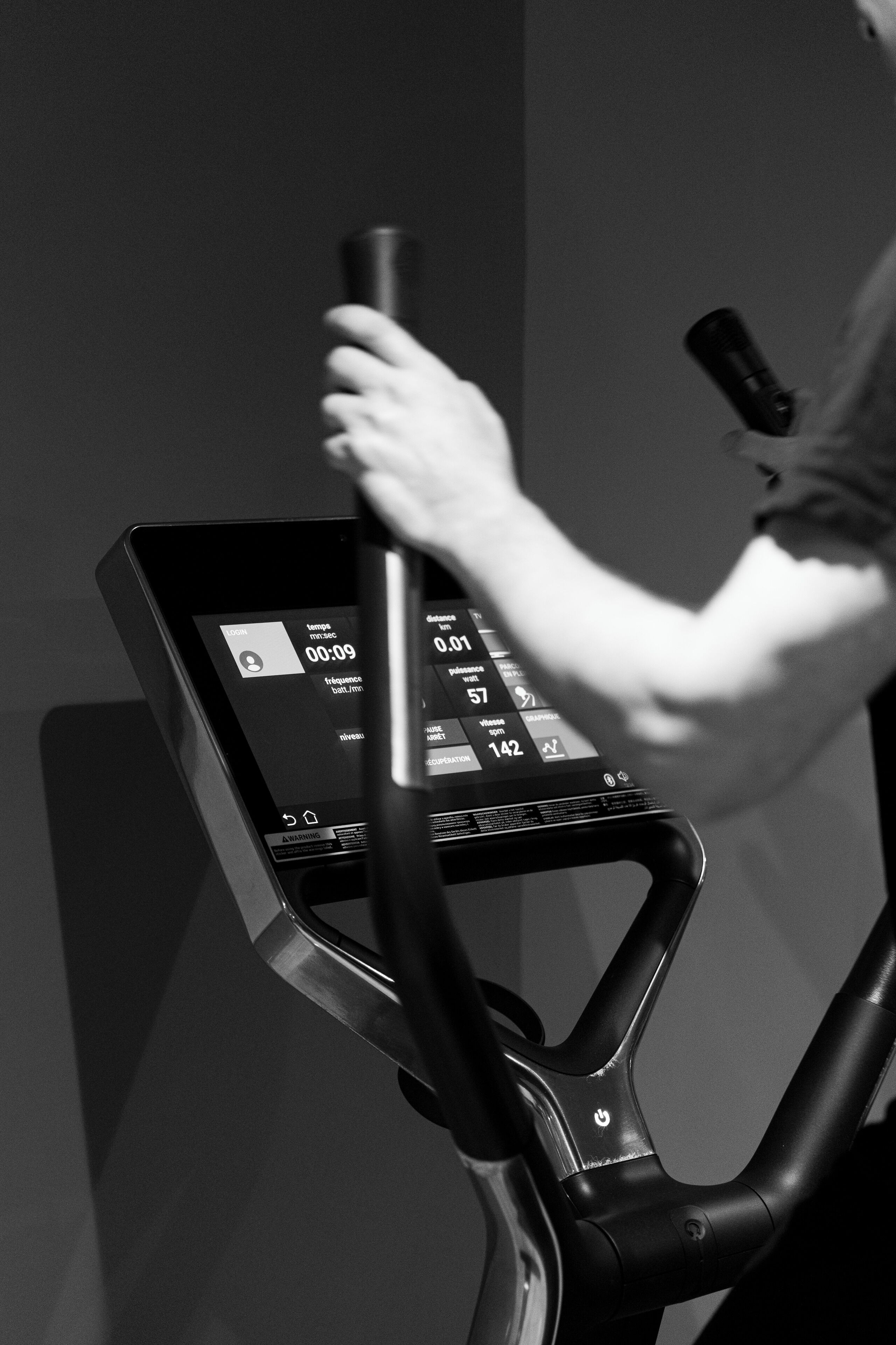 Iemand gebruikt een trainingsapparaat met een digitaal scherm.