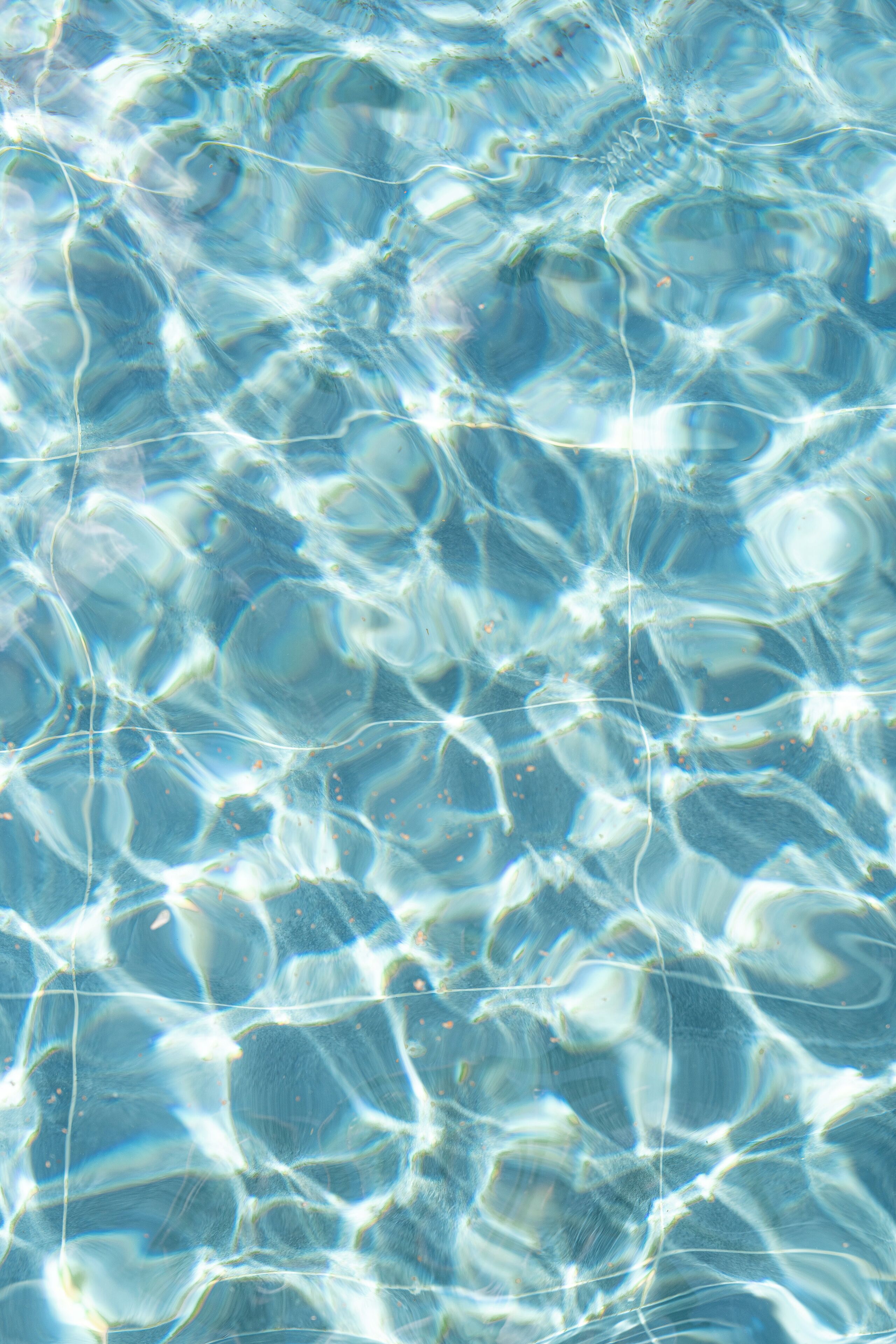Primer plano de agua cristalina y ondulante con reflejos de luz solar.