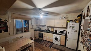 Une cuisine compacte avec des meubles en bois, un four encastré, un four à micro-ondes et un lave-linge.