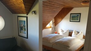 A bedroom with a wooden ceiling, a bed with white bedding, and a framed picture on the wall. - Berggasthaus Kandelhof (Simonswald)