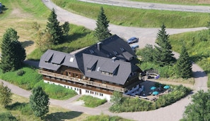 A large lodge with multiple floors, a ski lift, and outdoor seating.