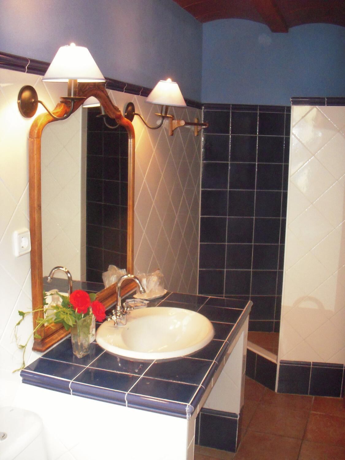 Ein Badezimmer mit Waschbecken, Spiegel und zwei Wandleuchten.