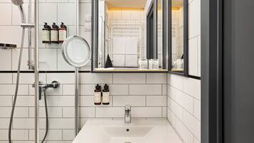 Une salle de bain moderne avec une douche, un lavabo et un miroir.