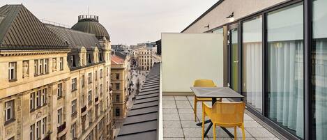 Un edificio moderno con terraza en la azotea, que incluye una mesa y sillas.