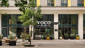 Un bâtiment moderne dont la façade porte l’inscription « VOCO BY IHG ».