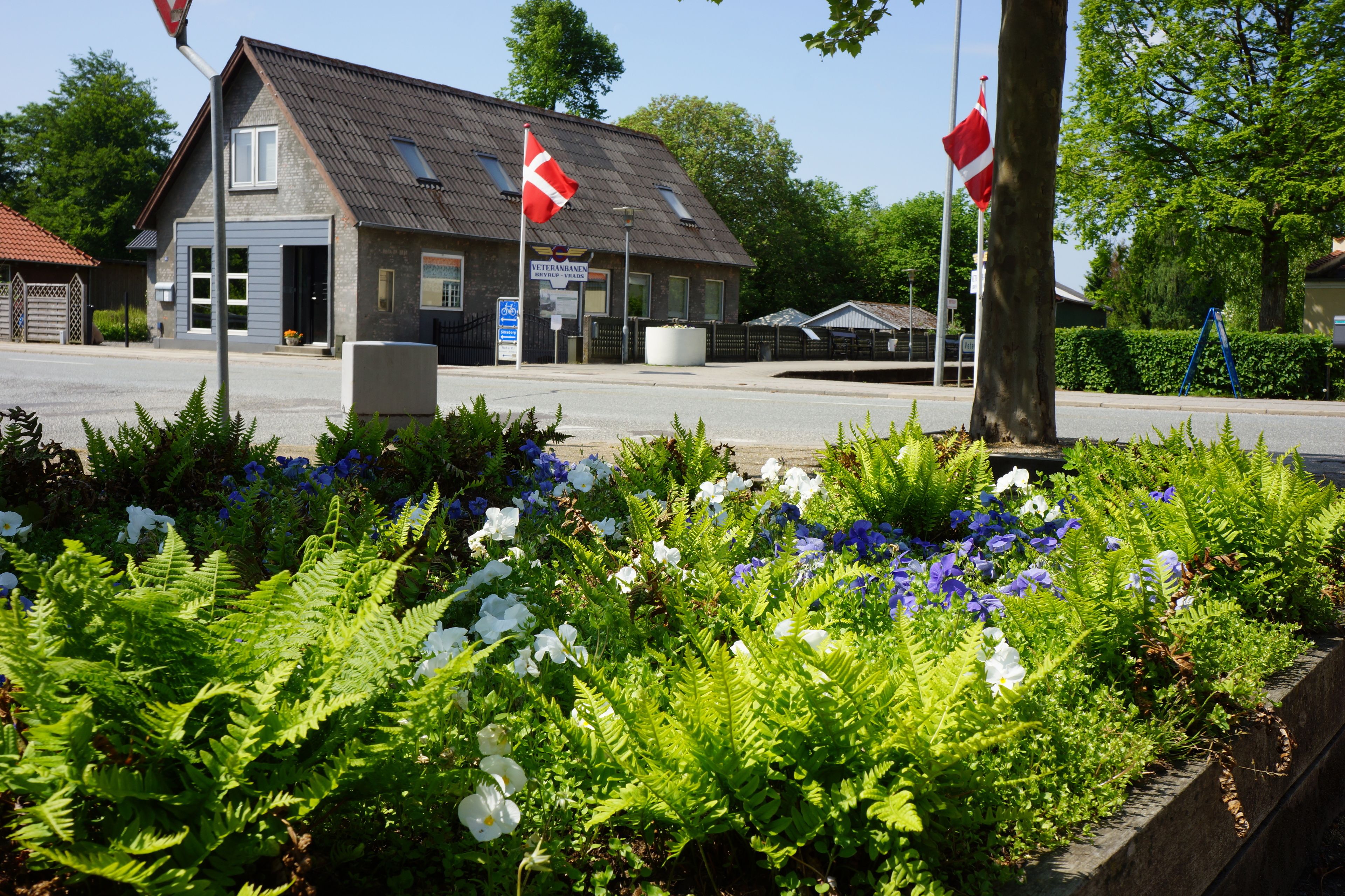 A building with a sloped roof and a flagpole with flags.