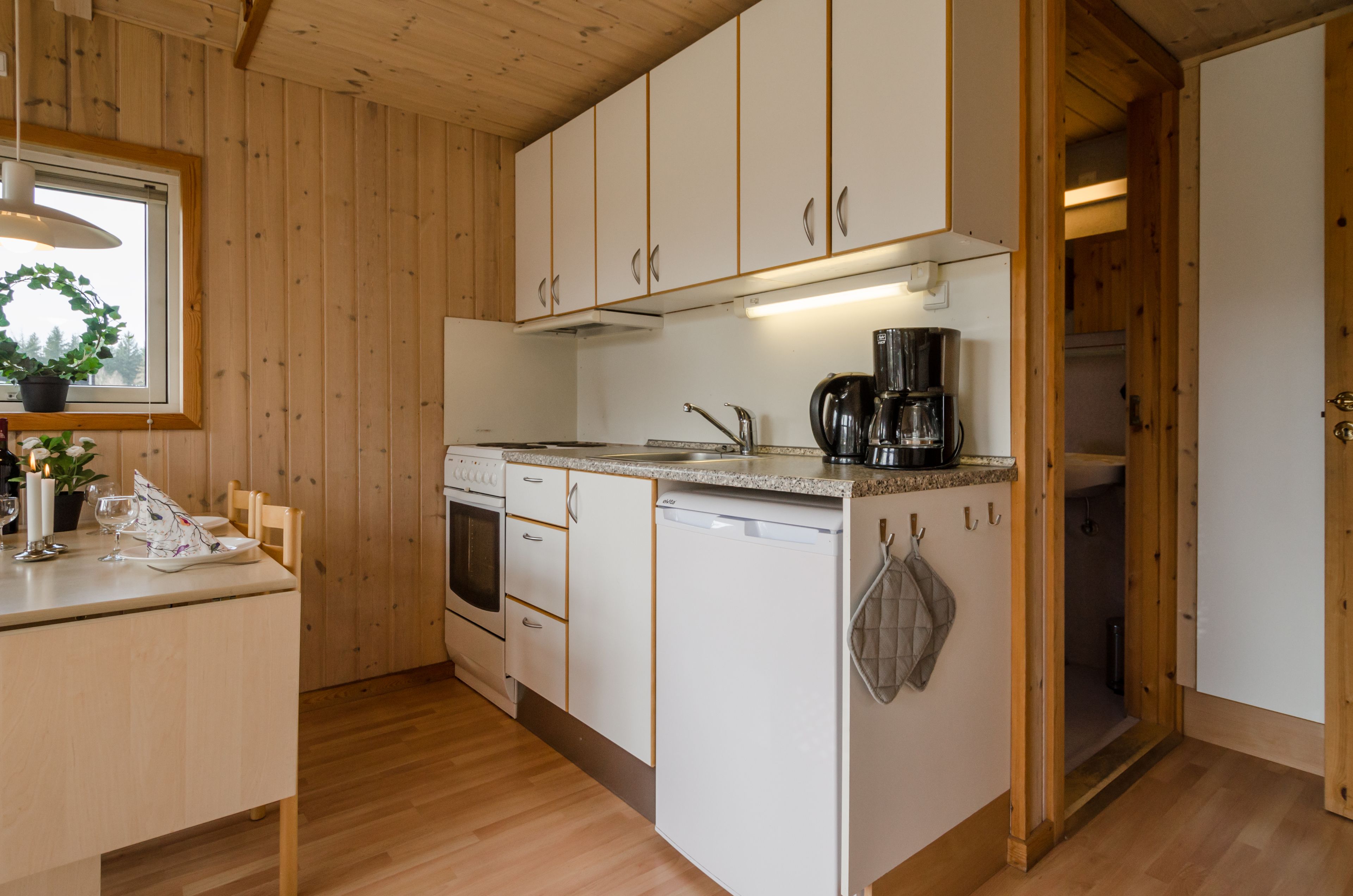 Une cuisine avec des meubles en bois, une machine à café et un lave-vaisselle.