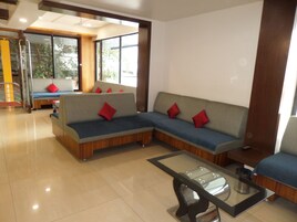 Una sala de estar moderna con un sofá modular, una mesa de centro de vidrio y vistas a un balcón.