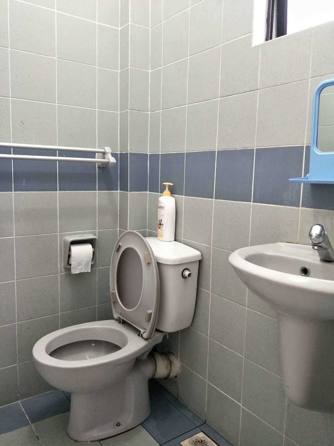 A bathroom with a toilet, a sink, and a hand dryer.