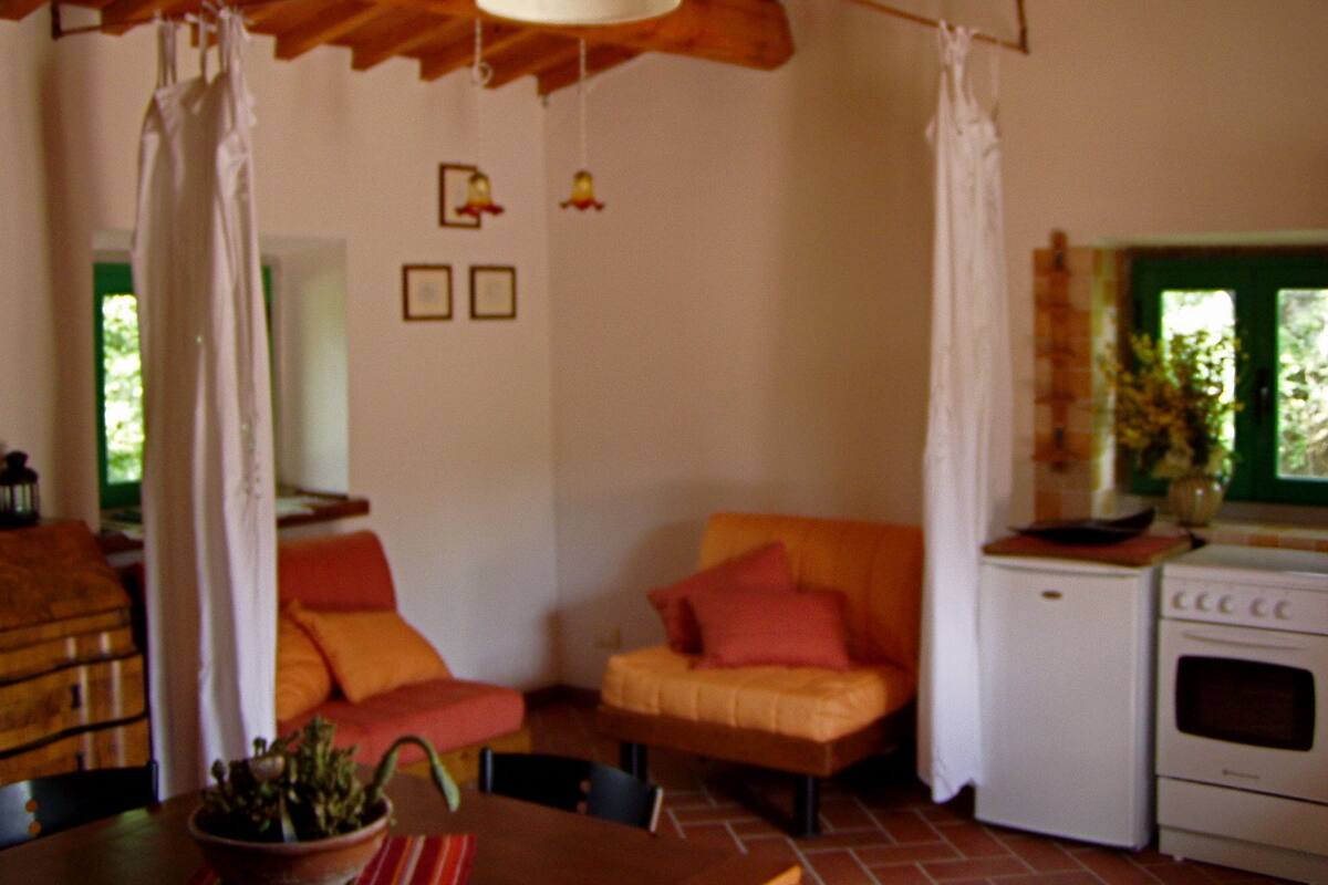 A cozy kitchen with a wooden ceiling, a stove, and a dining table with chairs.