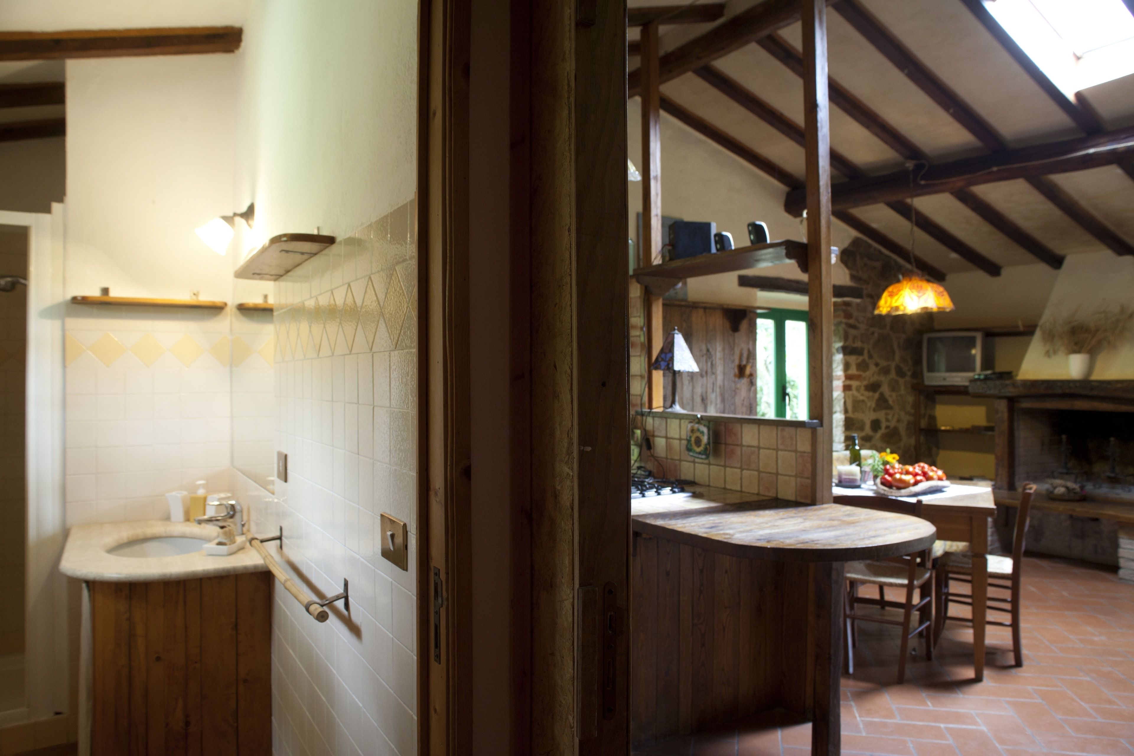 Una cucina rustica con un tavolo di legno, un lavello e un muro in pietra.
