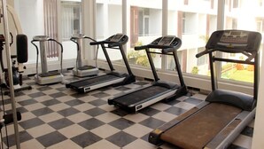 A gym with treadmills, ellipticals, and a stationary bike. - Saaral Resorts (Tarangambadi)