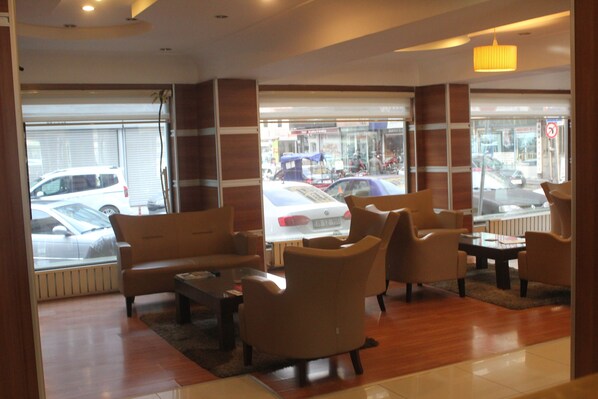 A hotel lobby with a sofa, armchairs, and a coffee table.