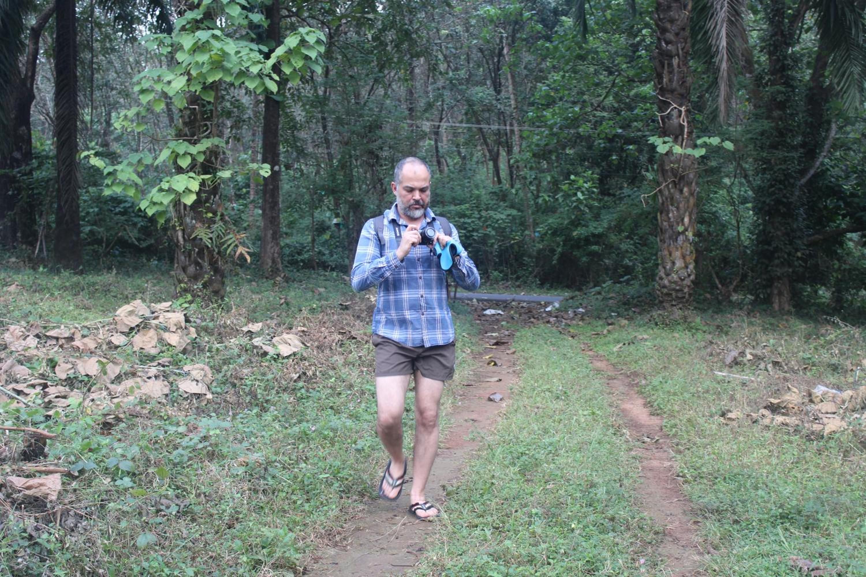 Una persona caminando por un sendero de tierra en un área boscosa.