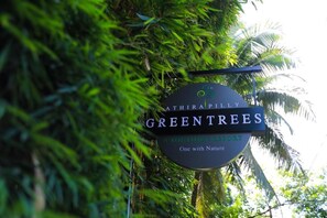 A sign for 'ATHIRAPILLY GREEN TREES' with a tagline 'A BOUTIQUE RESORT One with Nature'. - Athirapilly Green Trees (Chalakudy)
