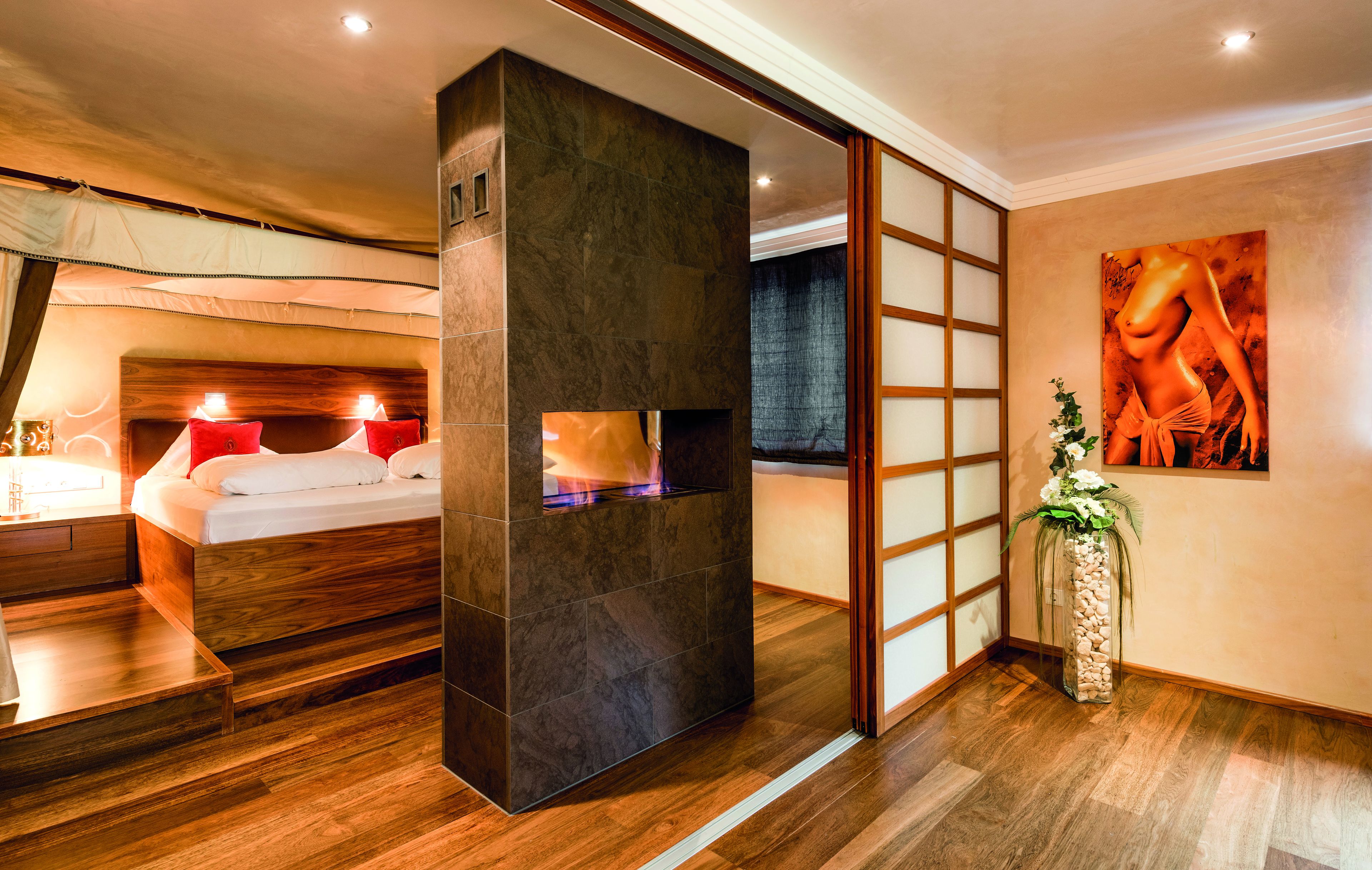 A modern bedroom with a large bed, a wooden headboard, and a decorative wall piece.