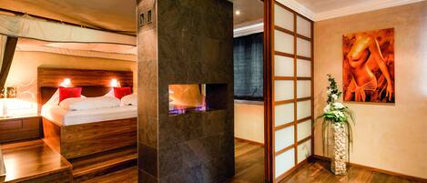 A modern bedroom with a large bed, a wooden headboard, and a decorative wall piece.