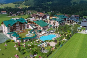 Un resort con una amplia piscina, varias edificaciones para huéspedes y céspedes bien cuidados.