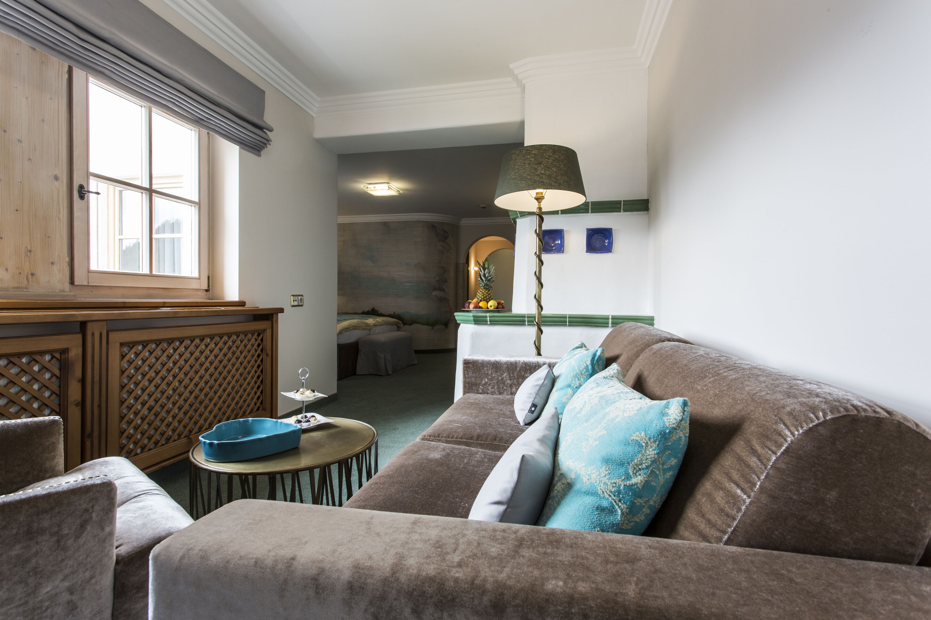 A living room with a brown sofa, a blue side table, and a wooden cabinet.