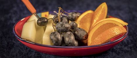 A bowl containing sliced apples, grapes, and orange slices.