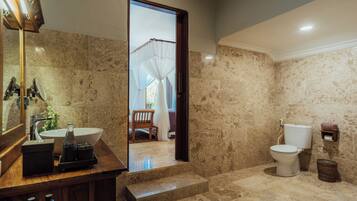 A bathroom with a marble floor, a sink, a toilet, and a mirror.