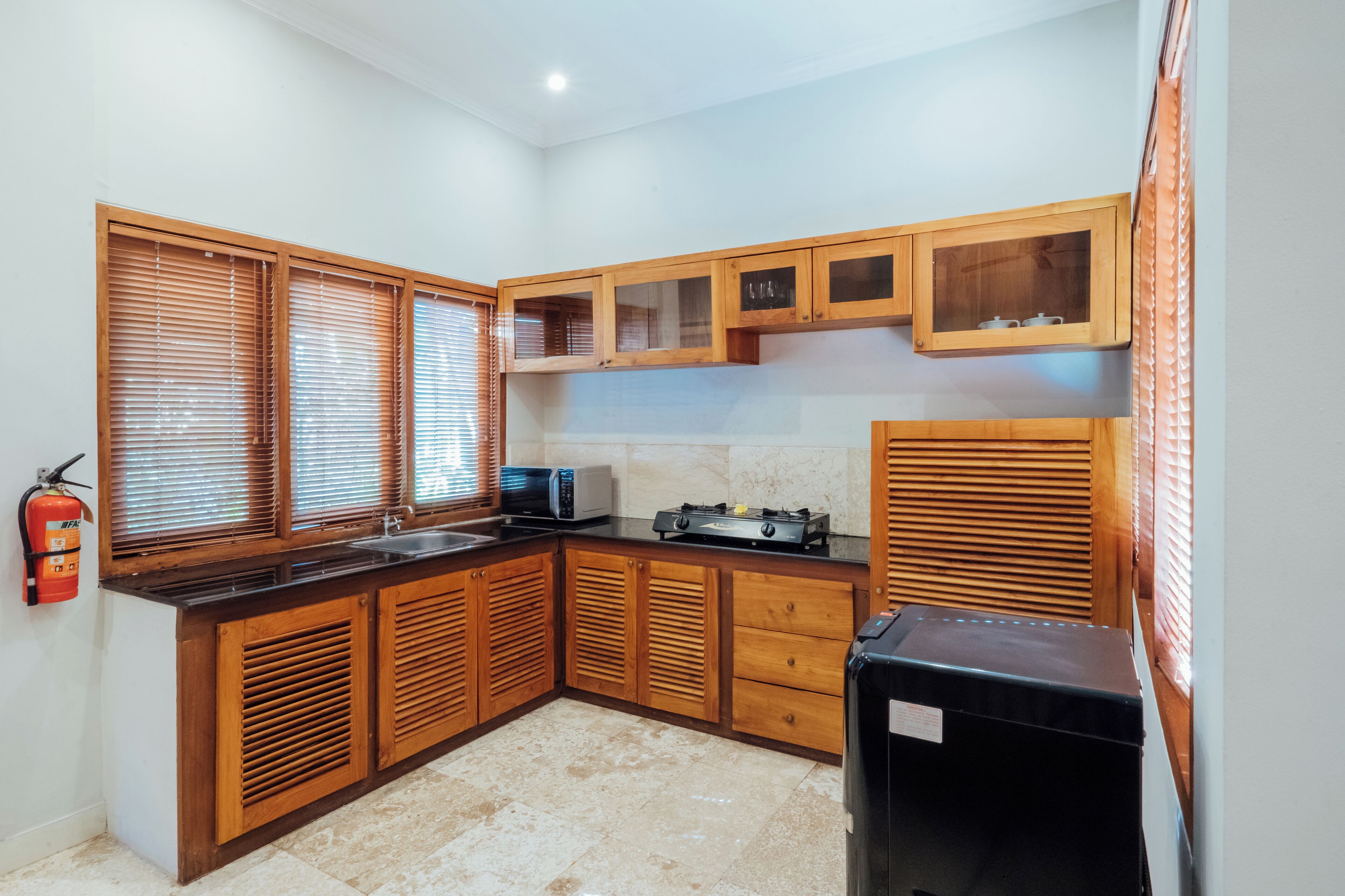 A kitchen with wooden cabinets, a microwave, and a refrigerator.