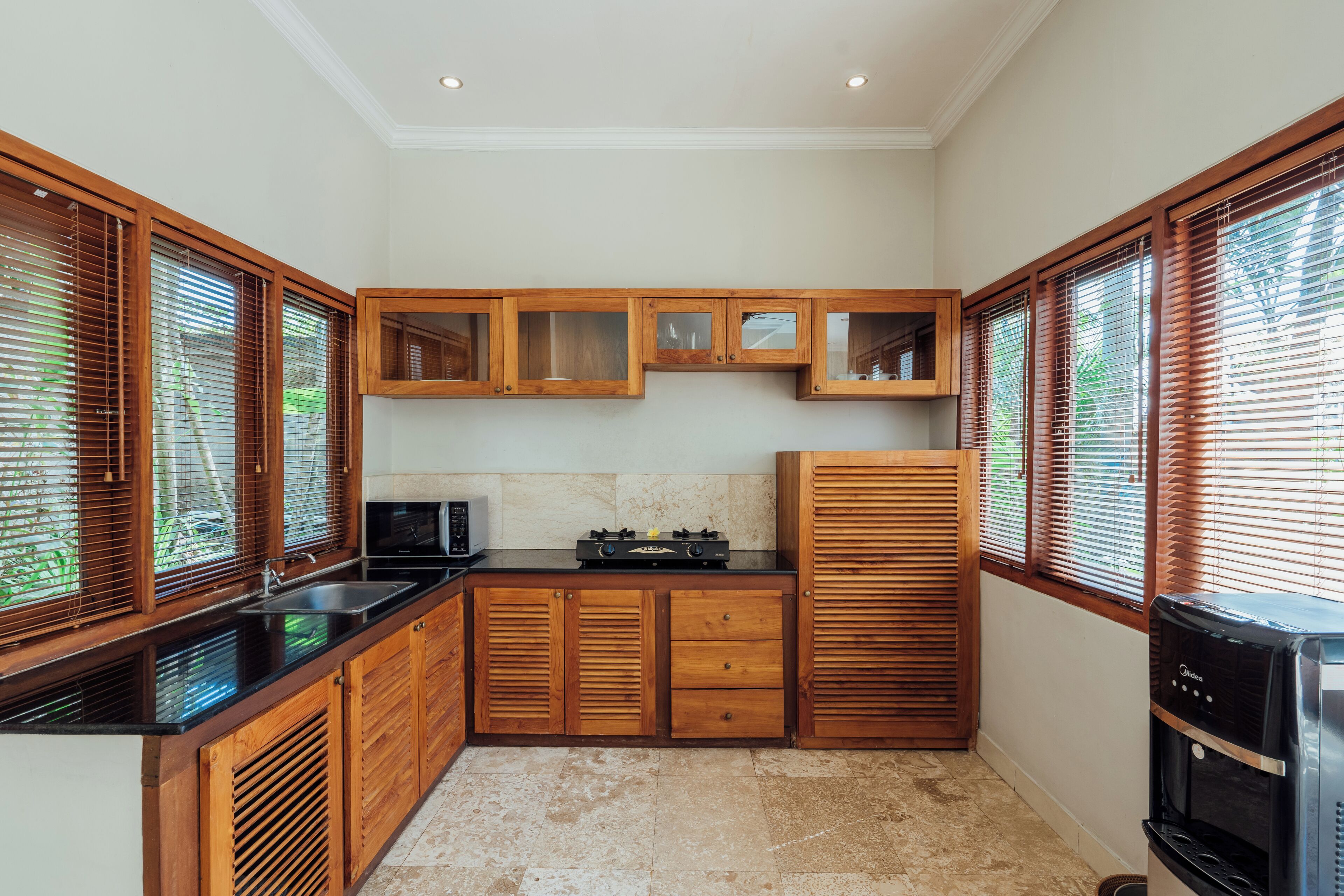 A compact kitchen with wooden cabinets, a built-in microwave, and a coffee machine.