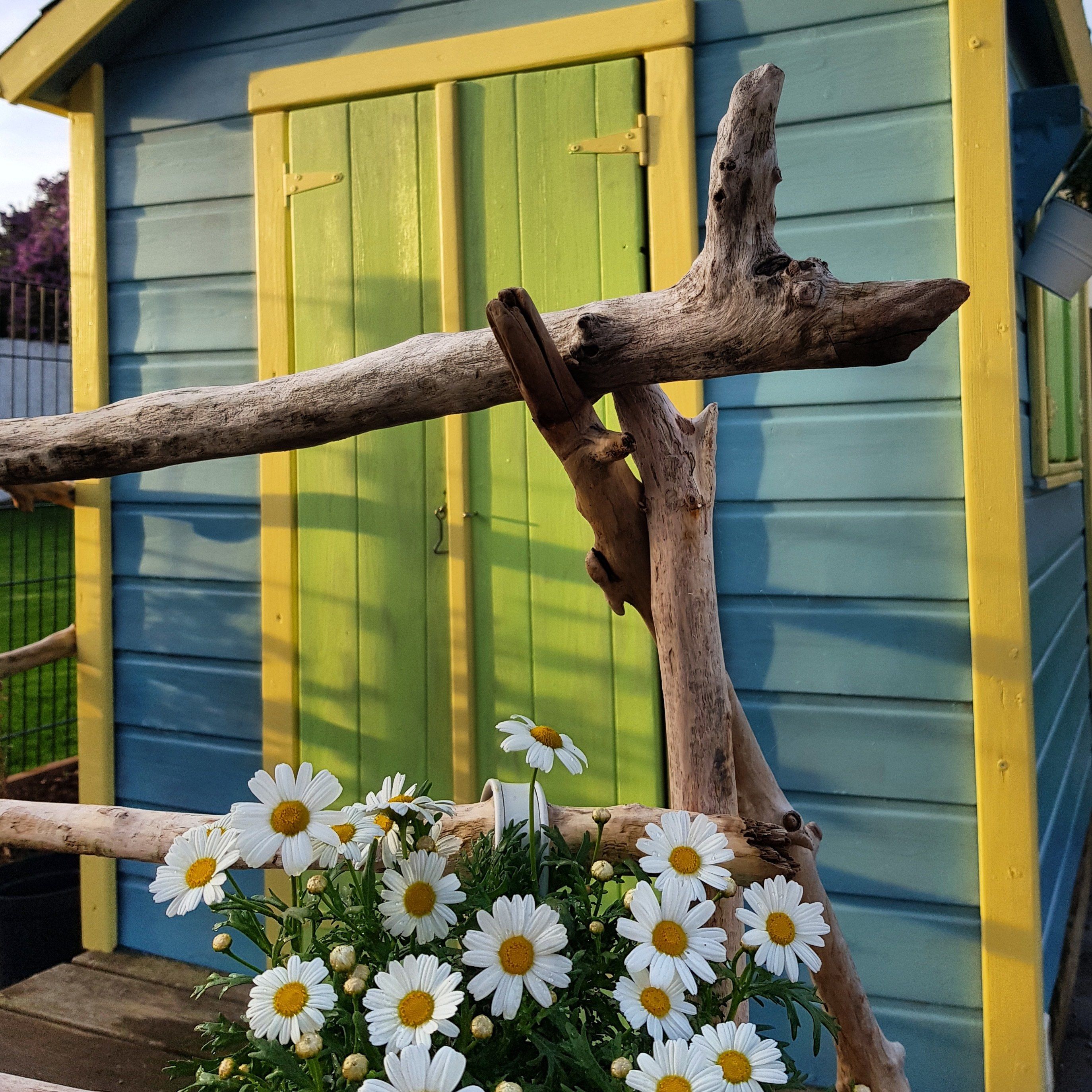 A wooden structure with a green door and a yellow trim.