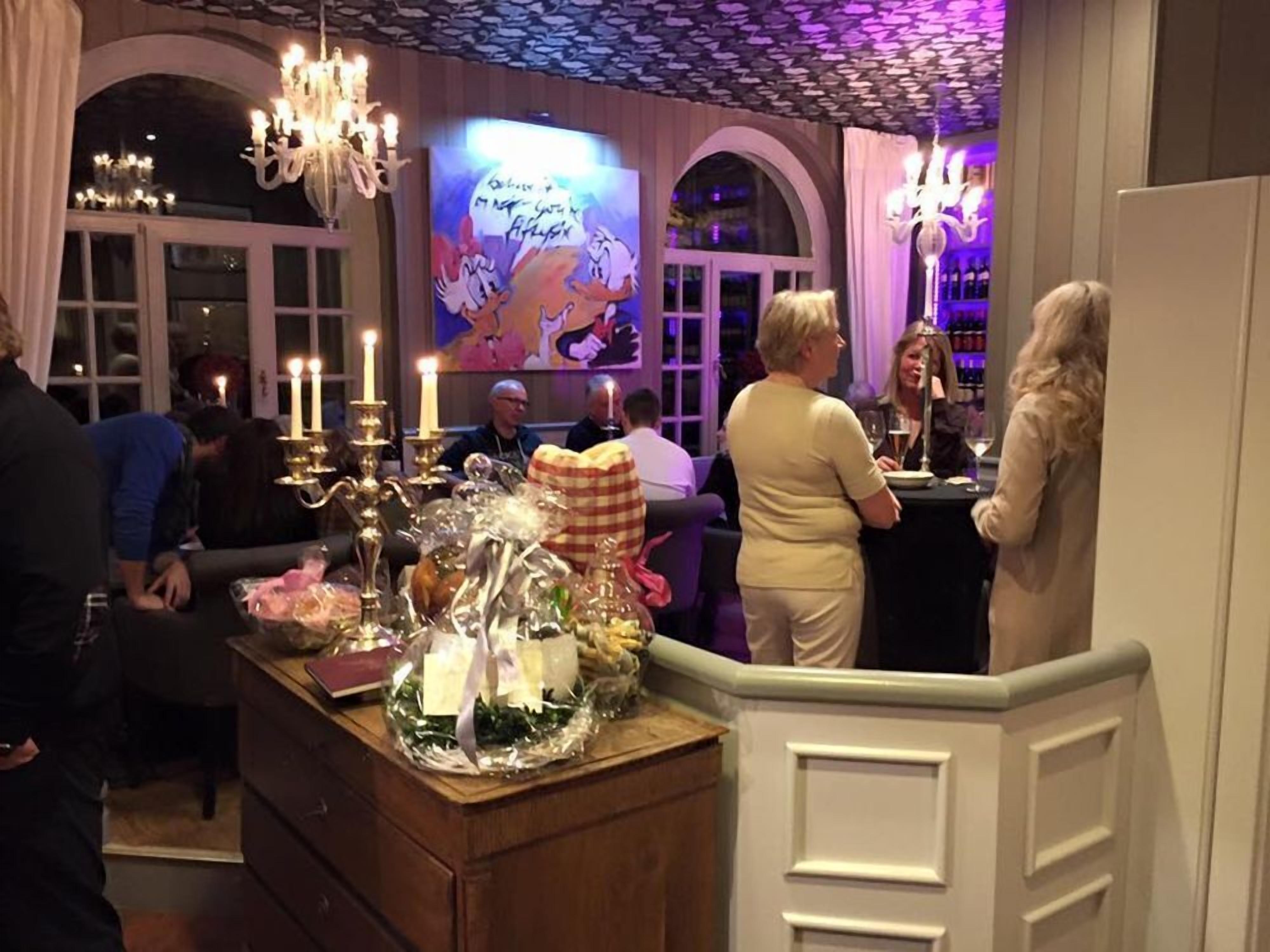 A restaurant interior with chandeliers, a bar area, and a wall with cartoon characters.