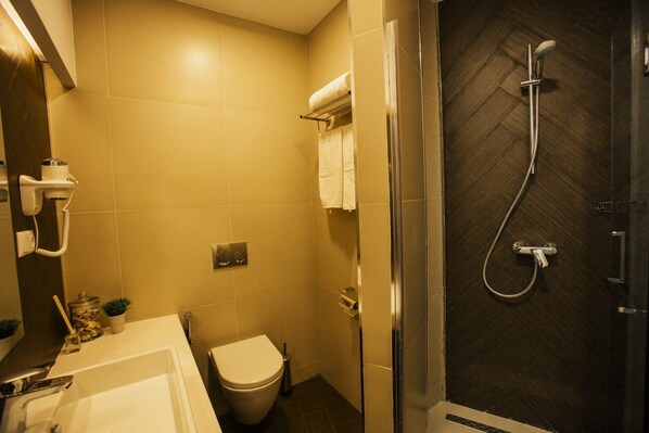 Un baño moderno con ducha, inodoro y lavamanos.