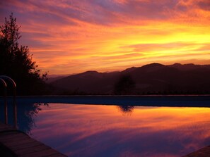 Una piscina al aire libre de temporada, sillones reclinables de piscina