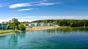 A lakeside hotel with modern architecture, a waterfront view, and a forested backdrop. - Maremüritz Yachthafen Resort (Waren (Müritz))