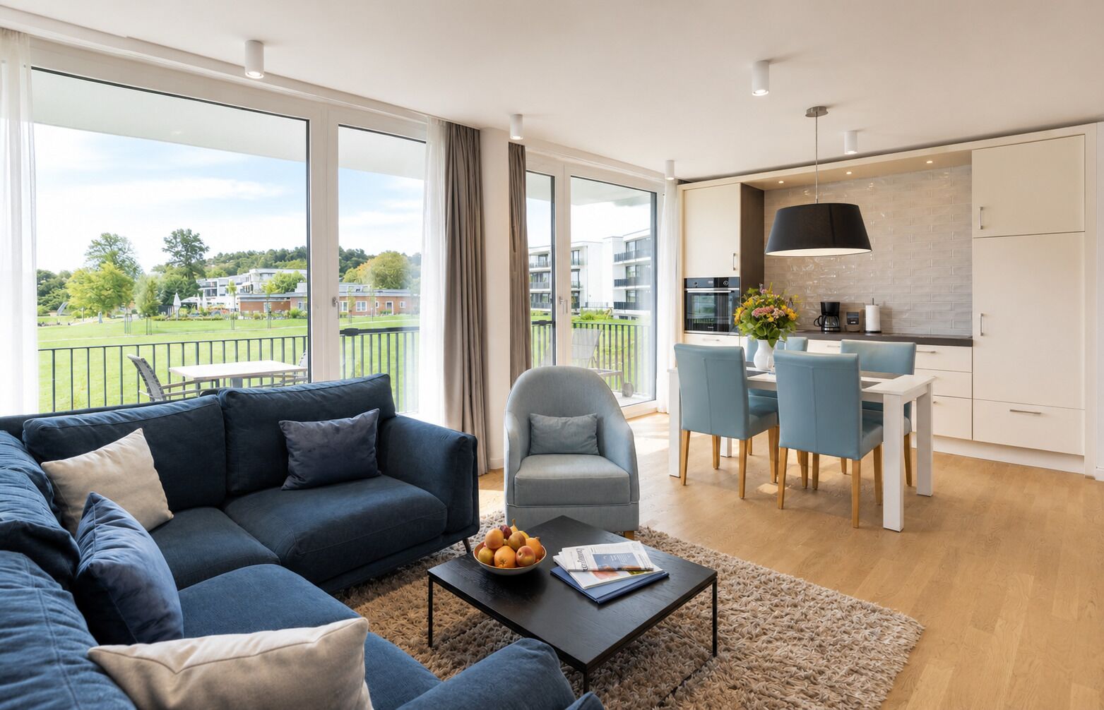 A modern living room with a sofa, armchair, and dining table.