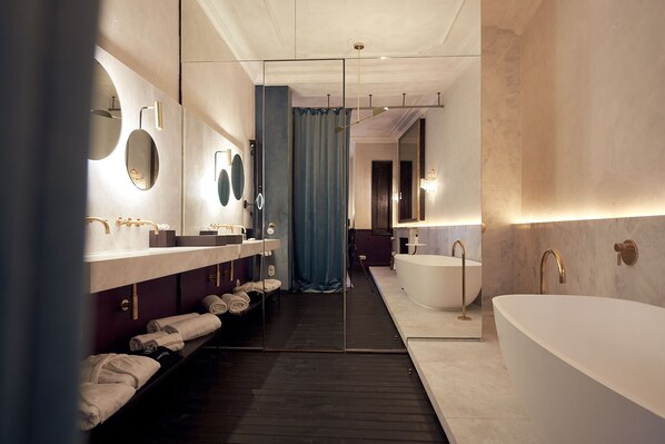 A modern bathroom with a large bathtub, a vanity with a mirror, and a shower area. - Can Bordoy Grand House Hotel GL Preferred Hotel (Palma de Mallorca)