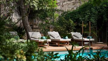 A poolside area with lounge chairs and a wooden deck.