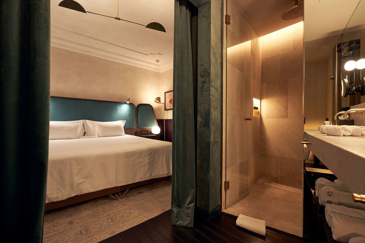 Une chambre d’hôtel comprenant un lit, un espace douche et une salle de bain.